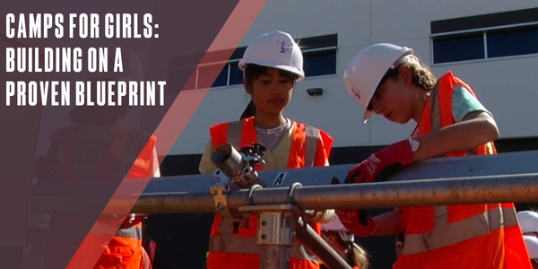 Image of girls in high vis and hard hats working on a metal beam