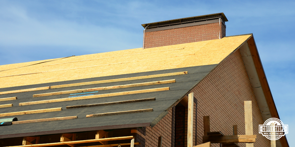 Image of a roof with some shingles installed, toe boards and some roof deck exposed